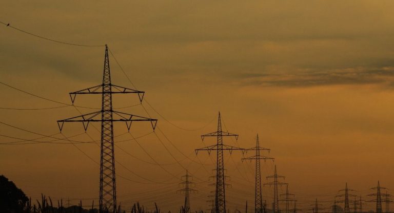 Pylônes et lignes électriques haute tension au crépuscule sur le réseau de transport