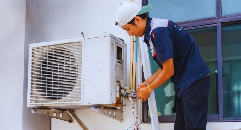 Technicien réglant l'unité extérieure d'une pompe à chaleur air-air